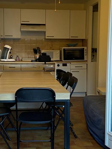 une cuisine avec une table et des chaises dans une pièce dans l'établissement Appartement idéal famille, à Carqueiranne