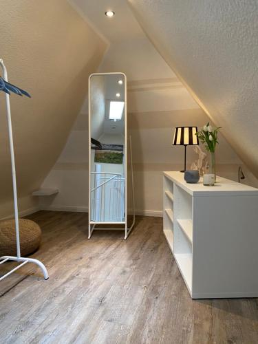 a room with a mirror and a dresser in a attic at Sylt-Traum Kampen in Kampen
