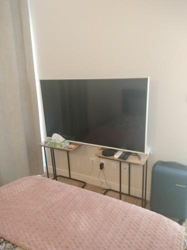 - une chambre avec une télévision sur un banc et un lit dans l'établissement Favorite hangout, à Saint-Ouen