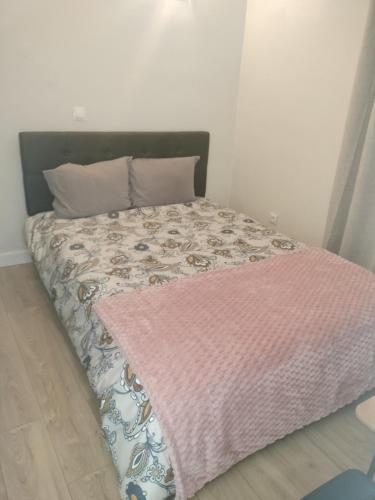 Ce lit se trouve dans une chambre dotée d'une couverture rose. dans l'établissement Favorite hangout, à Saint-Ouen