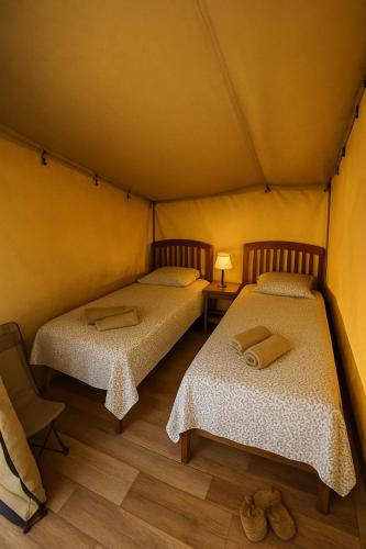 une chambre avec deux lits dans une tente dans l'établissement La tente de Mercone - Oru, à Corte