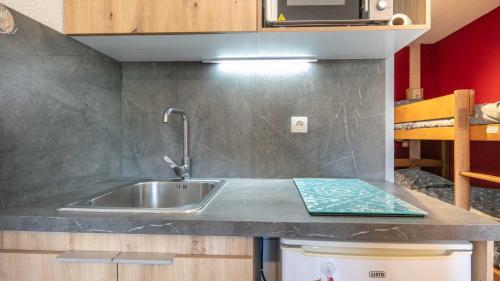 un comptoir de cuisine avec un évier et un micro-ondes dans l'établissement Le Vernon N1021 - ST4, à Chamrousse