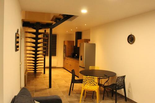 un salon avec une table et des chaises et une cuisine dans l'établissement Au jardin d'Eden, à Cuchery