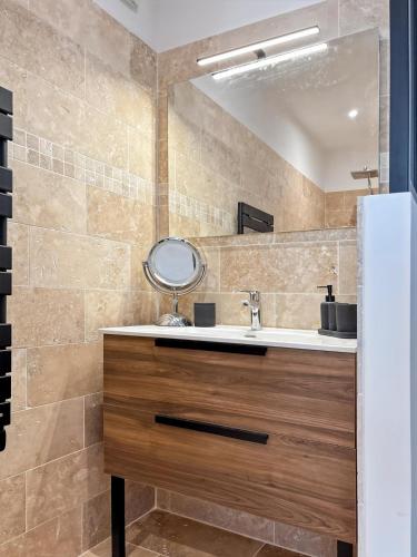 une salle de bain avec un lavabo et un miroir dans l'établissement Le Mas des Fontaines, à Châteaurenard