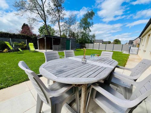 une table et des chaises en bois dans une cour dans l'établissement Le Gite des Marais Charming Holiday Home with Garden in Carentan-les-Marais, à Saint-Hilaire-Petitville