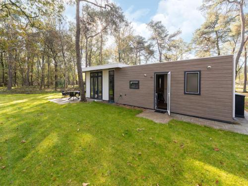 une petite maison dans un champ avec une cour dans l'établissement Vakantie woning "Huisje Boszicht", à Haarle