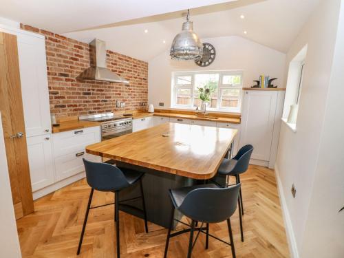 a kitchen with a wooden table and blue chairs at Farm View House in Melton Mowbray