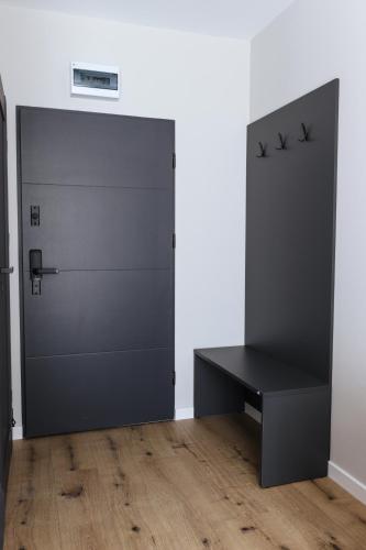 a locker room with a black door and a bench at W64 Apartamenty in Płock