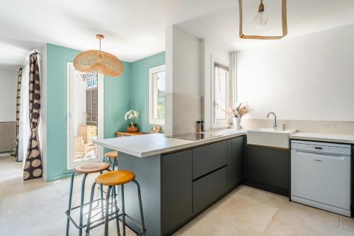 - une cuisine avec un évier et deux tabourets de bar dans l'établissement La Saltarelle Appartement moderne 750m du port, à Cassis