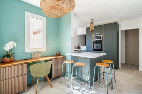 - une cuisine avec des murs bleus et des tabourets de bar dans l'établissement La Saltarelle Appartement moderne 750m du port, à Cassis
