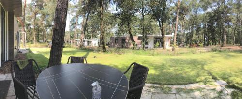 - une table et des chaises sur une terrasse avec vue sur la cour dans l'établissement Vakantie woning "Huisje Boszicht", à Haarle
