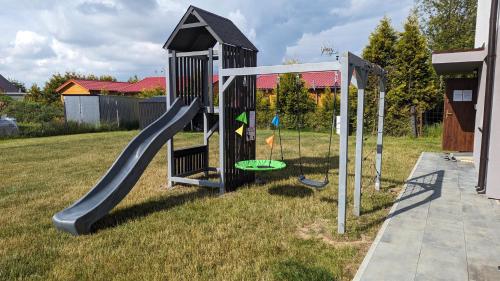 a playground with a slide in a yard at Lavanda Apartamenty in Chłopy