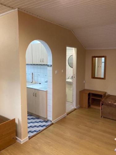 an empty kitchen with an archway in a room at Domek Letniskowy Napiórki in Przechlewo