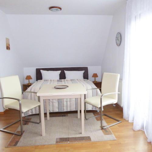 a dining room with a table and two chairs at Ferienwohnung-3-im-Haus-Baltique in Glowe
