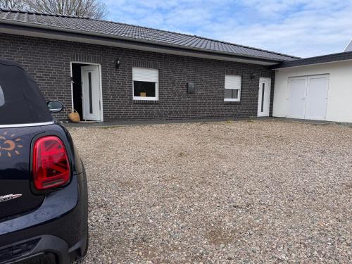a car parked in front of a brick house at Ferienhaus Nordkönig mit Sauna und Whirlpool in Langen