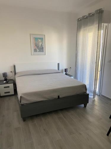 a bedroom with a bed in a white room at La Giara in Alghero