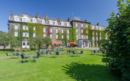 a large building with tables and chairs in the grass at Old Swan Hotel in Harrogate