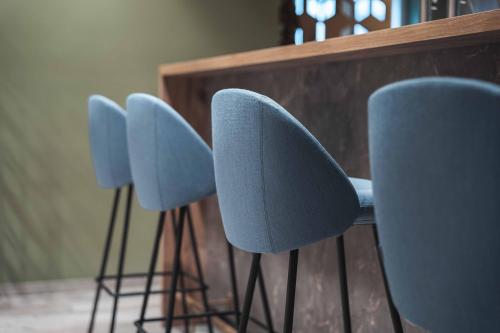 a row of blue chairs next to a table at BinderS Budget City-Mountain Hotel in Innsbruck