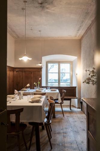 a dining room with a table and a piano at Ansitz Thierburg Suites in Merano