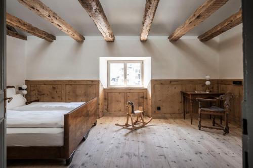 a bedroom with a bed and a desk and a window at Ansitz Thierburg Suites in Merano