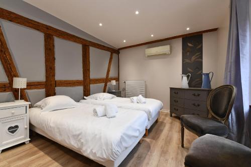 - une chambre avec 2 lits et une chaise dans l'établissement Appartement Bredala avec Climatisation, à Colmar