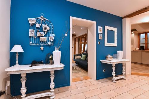 a blue room with two tables and a blue wall at Appartement Bredala avec Climatisation in Colmar