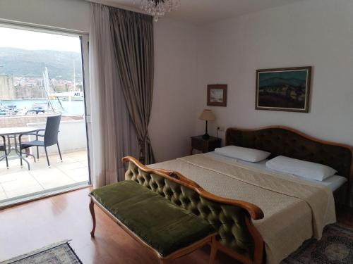 a bedroom with a bed and a balcony with a table at Villa Angel sea view in Trogir