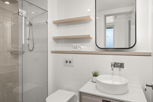 une salle de bain blanche avec lavabo et douche dans l'établissement Surfers Paradise Skyline 3BR Free CP Ocean View Apartment, à Gold Coast