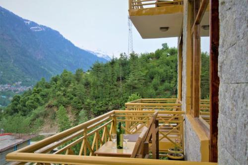 a wooden balcony with a view of a mountain at V V Aero a wooden exotic stay Near Old Manali in Manāli