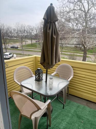 a table and chairs on a balcony with a window at yellow house downtown in Des Moines