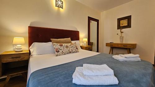a bedroom with a large bed with two towels on it at Asis de Marratxinet Turismo de Interior in Marratxí 
