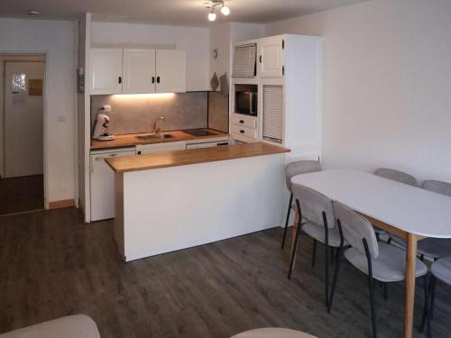 une cuisine avec des armoires blanches et une table et des chaises dans l'établissement Appartement 2 pièces, 6 pers. aux Orres avec balcon - FR-1-322-171, aux Orres