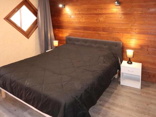 une chambre avec un lit et un mur en bois dans l'établissement Appartement 2 pièces, 6 pers. aux Orres avec balcon - FR-1-322-171, aux Orres
