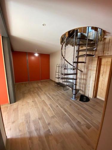 - un salon avec un escalier en colimaçon dans l'établissement Charming Gite avec beau panorama, à Arsac-en-Velay