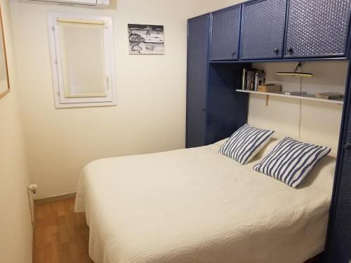 une chambre avec un lit avec deux oreillers dessus dans l'établissement Maison de vacances climatisée, à Argelès-sur-Mer