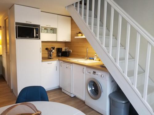 une cuisine avec un lave-linge et un escalier dans l'établissement Maison de vacances climatisée, à Argelès-sur-Mer