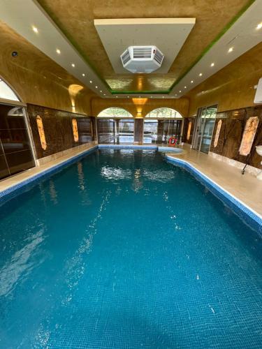 a large swimming pool with blue water in a building at Dom na Wyłączność z Wanną z Hydromasażem, Sauną i Basenem in Mucharz