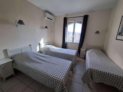 deux lits jumeaux dans une chambre avec fenêtre dans l'établissement Maison climatisée 5 pers avec terrasse, parking, WiFi, et équipements complets dans quartier calme - FR-1-382-129, à Grospierres