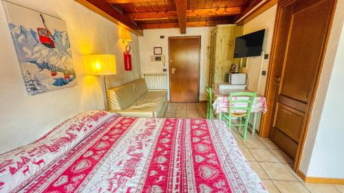 a bedroom with a bed and a living room at Residence Villa Frejus in Bardonecchia