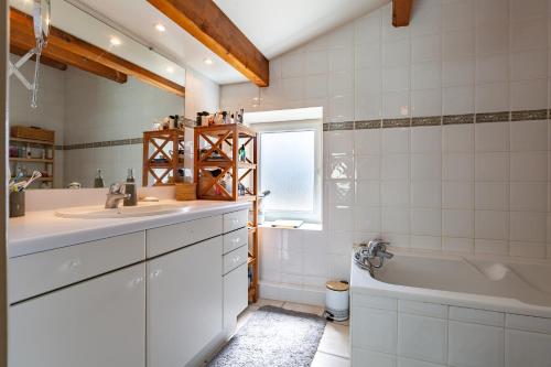 a bathroom with a sink and a bath tub at La Villa du bonheur in Puy-Saint-Martin