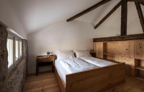 a bedroom with a wooden bed and a wooden table at Ansitz Thierburg Suites in Merano