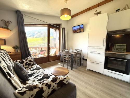 un salon avec un canapé et une cuisine avec une table dans l'établissement Appartement 2 pièces à Praz Sur Arly, parking, proche pistes, pour 5 personnes - FR-1-603-68, à Praz-sur-Arly