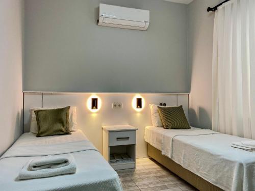 a room with two beds and a table with a window at İZAN VİLLA BAKIŞ APARTMENTS in Bodrum City