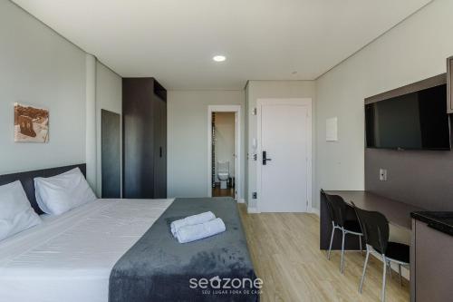 a bedroom with a bed and a desk and a television at TCO - Apartamentos no Centro Histórico Porto Alegre/RS in Porto Alegre