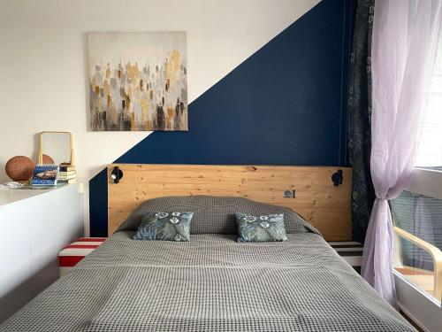 une chambre avec un lit avec un mur bleu dans l'établissement Confortable studio avec loggia fermée, 29m², wifi - FR-1-553-260, à Balaruc-les-Bains