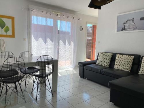 un salon avec un canapé, une table et des chaises dans l'établissement Bel Appartement T2 avec Terrasse et Garage à Balaruc-les-Bains - FR-1-553-269, à Balaruc-les-Bains
