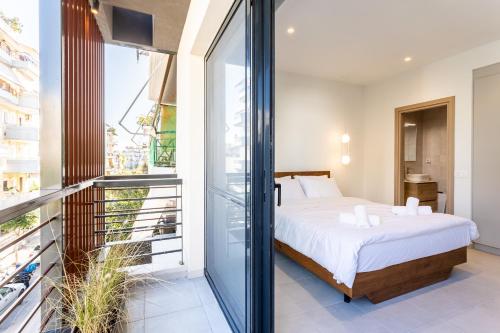 a bedroom with a bed and a balcony at Grec Suites Dafni, Athens by GrecCollection in Athens