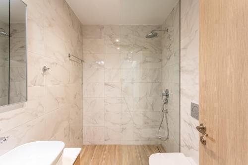 a bathroom with a shower with a toilet and a sink at Grec Suites Dafni, Athens by GrecCollection in Athens