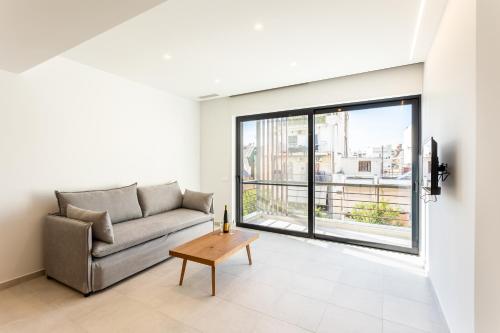 a living room with a couch and a large window at Grec Suites Dafni, Athens by GrecCollection in Athens