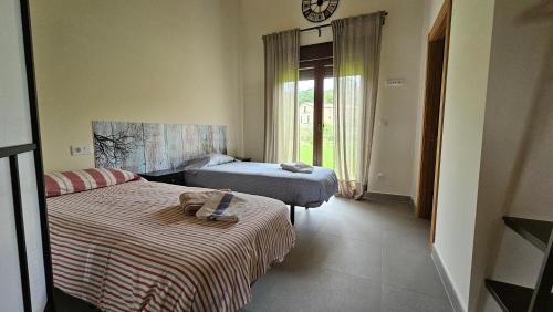 a bedroom with two beds and a clock on the wall at Mi Casa en Guriezo in Angostina